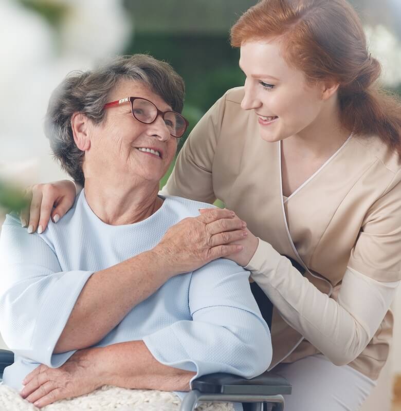 Eldre kvinne med hjerneslag får hjelp av sykepleier